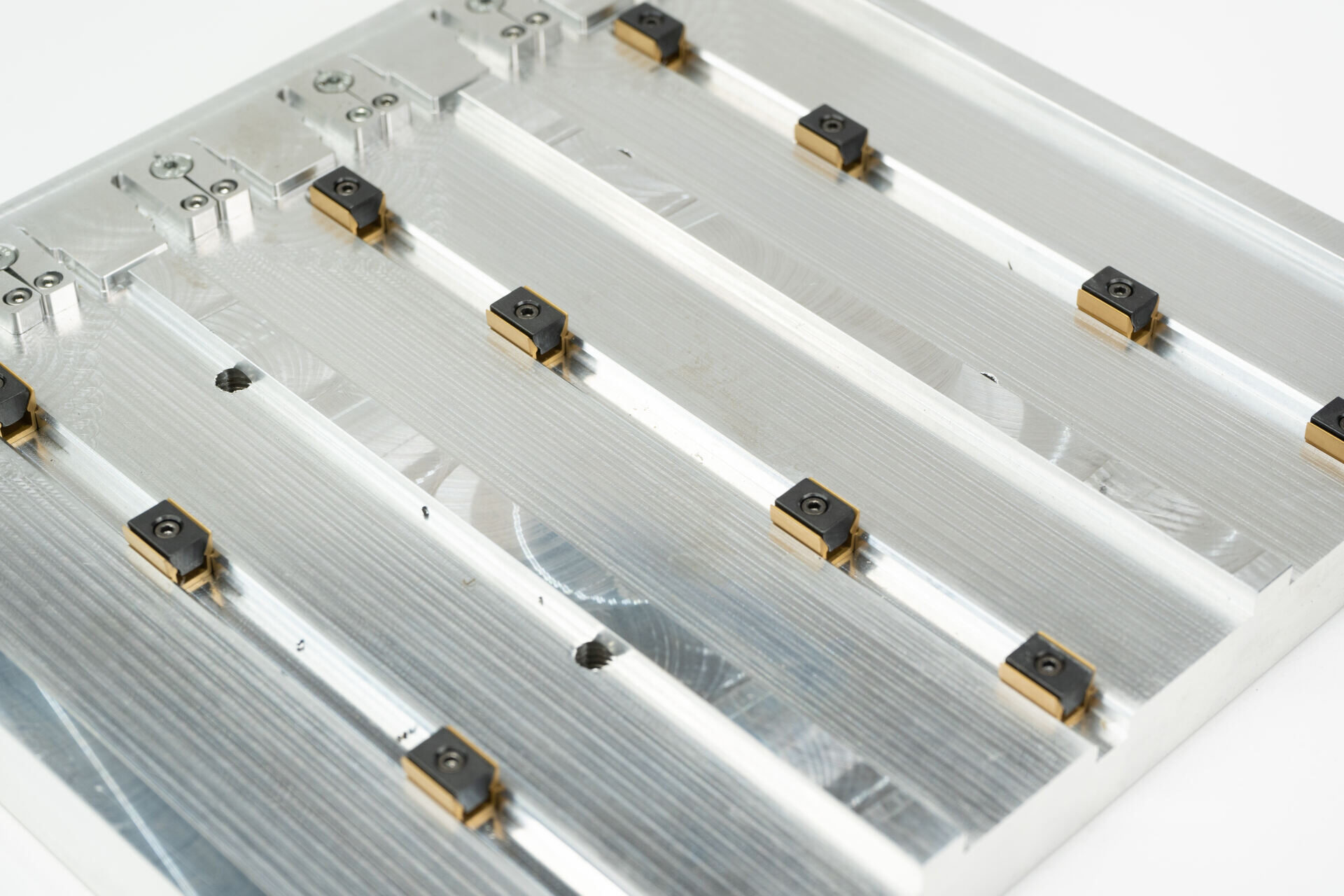 Machined fixture rails with brass inserts